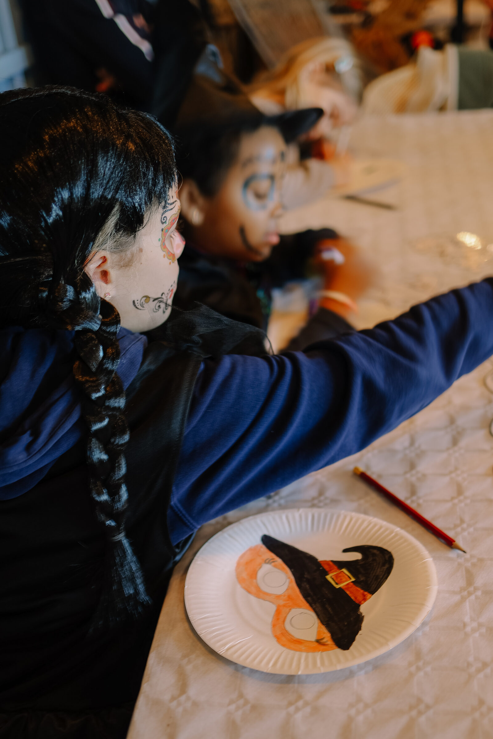 A child decorating a bat-shaped treat during the Halloween workshop
