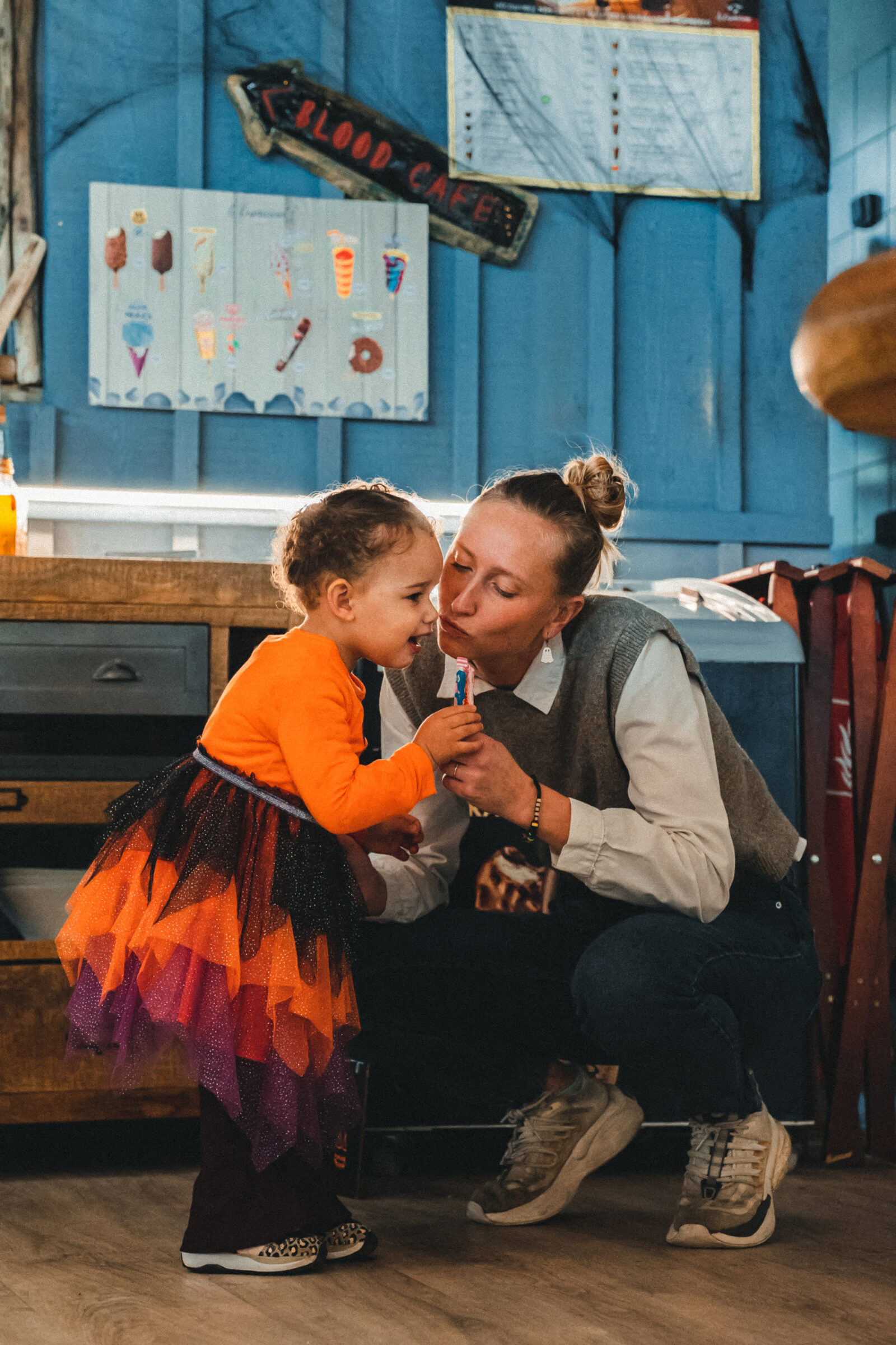A costumed activity leader helping a child during the Halloween activities
