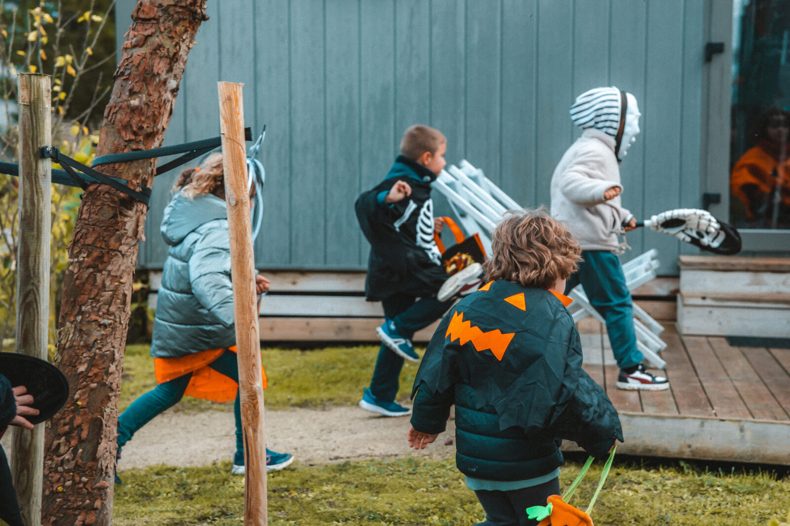 Children running with buckets in hand during trick-or-treating at the campsite
